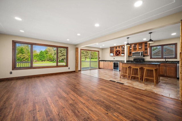 living room with wine cooler, wood finished floors, recessed lighting, and baseboards