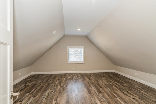 additional living space with lofted ceiling, dark wood-style floors, and baseboards