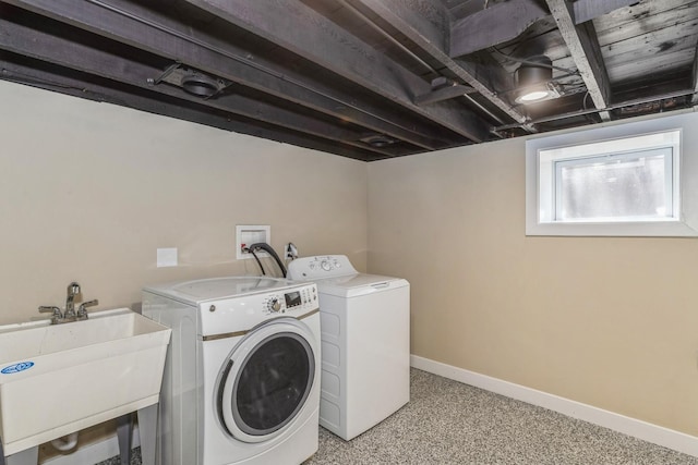 laundry area featuring a sink, washing machine and clothes dryer, laundry area, and baseboards