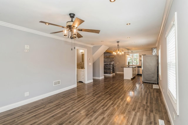 unfurnished living room featuring crown molding, visible vents, baseboards, recessed lighting, and ceiling fan with notable chandelier