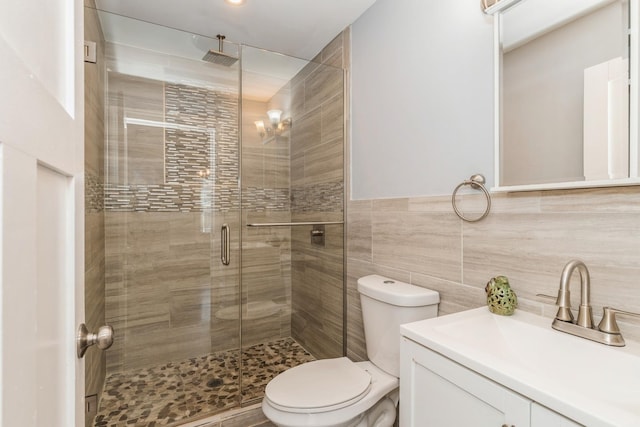 bathroom featuring a stall shower, toilet, and vanity