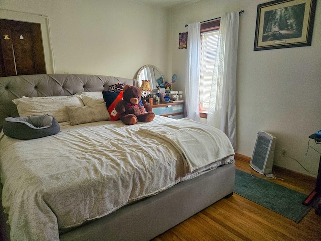 bedroom featuring baseboards and wood finished floors