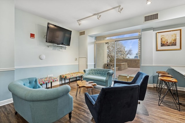 living room featuring track lighting, wood finished floors, and baseboards