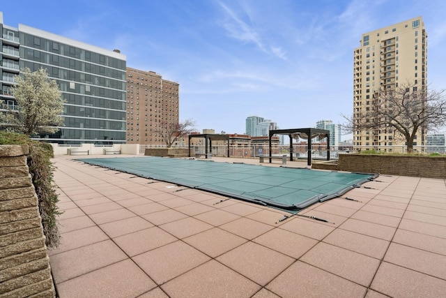 community pool with a patio and fence