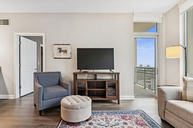 living area with healthy amount of natural light, wood finished floors, and baseboards