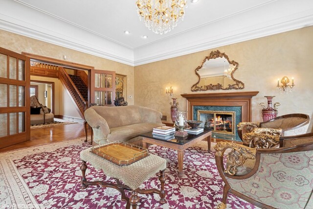 546 Oak Knoll Rd, Barrington Hills, IL 60010 - living area with crown molding, stairway, an inviting chandelier, a fireplace, and wood finished floors