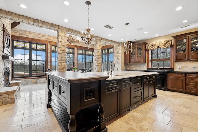 546 Oak Knoll Rd, Barrington Hills, IL 60010 - kitchen featuring visible vents, a wealth of natural light, decorative backsplash, and a center island with sink