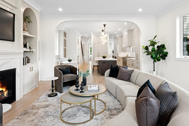 3452 N Bell Ave, Chicago, IL 60618 - living room featuring light wood-type flooring, arched walkways, recessed lighting, a fireplace, and built in shelves