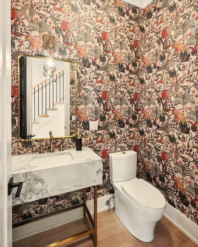 3452 N Bell Ave, Chicago, IL 60618 - half bathroom with wallpapered walls and wood finished floors