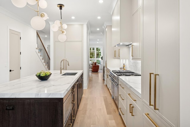 3452 N Bell Ave, Chicago, IL 60618 - kitchen with high end stove, extractor fan, light wood-type flooring, an island with sink, and recessed lighting