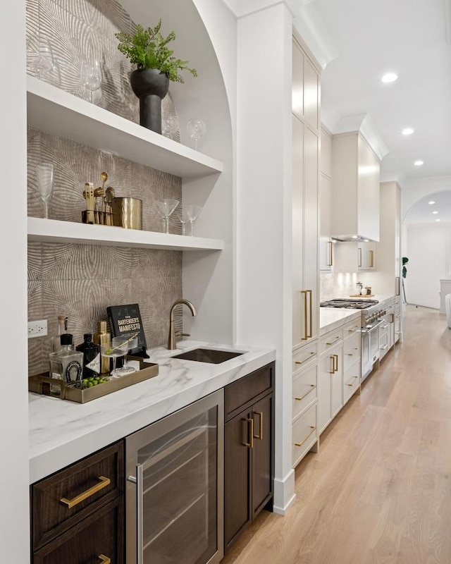 3452 N Bell Ave, Chicago, IL 60618 - indoor wet bar with beverage cooler, light wood-style floors, arched walkways, recessed lighting, and stovetop