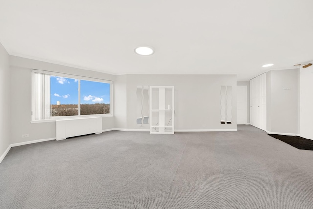 unfurnished living room featuring radiator, baseboards, and carpet floors