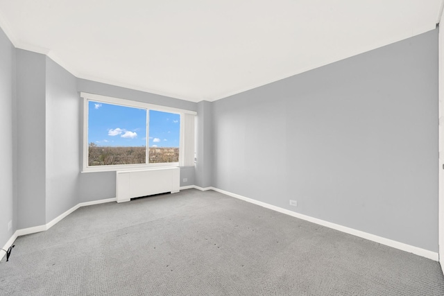 unfurnished room with radiator, baseboards, and carpet