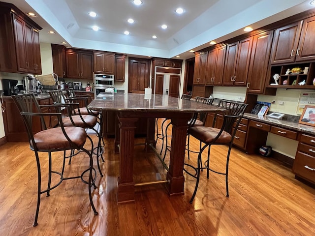 37418 N Fox Hill Dr, Wadsworth, IL 60083 - kitchen featuring light wood finished floors, built in desk, paneled built in refrigerator, a breakfast bar, and a kitchen island