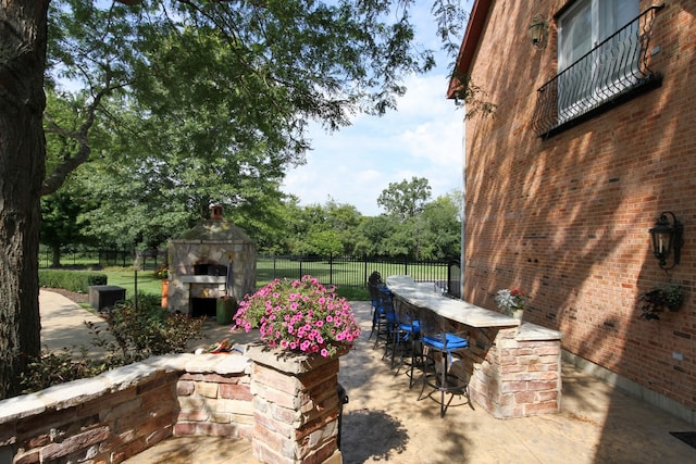 37418 N Fox Hill Dr, Wadsworth, IL 60083 - view of patio / terrace with fence, an outdoor stone fireplace, and outdoor dry bar