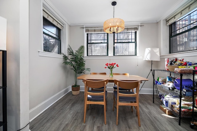 dining room with wood finished floors, crown molding, baseboards, and an inviting chandelier