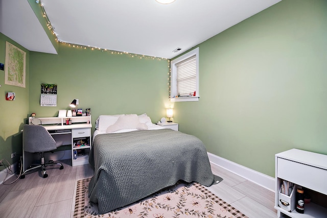 bedroom with baseboards and visible vents