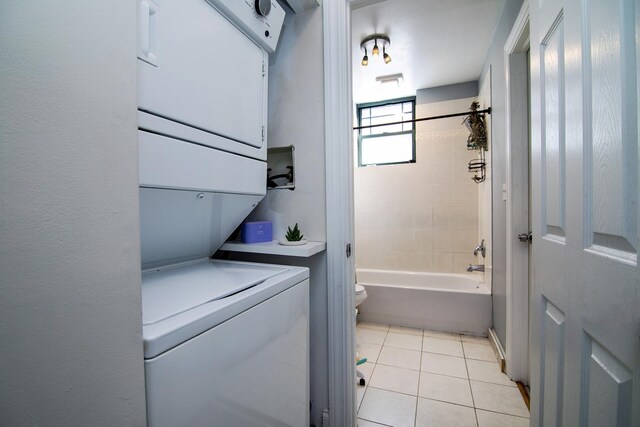 clothes washing area with stacked washer / dryer, laundry area, and light tile patterned floors