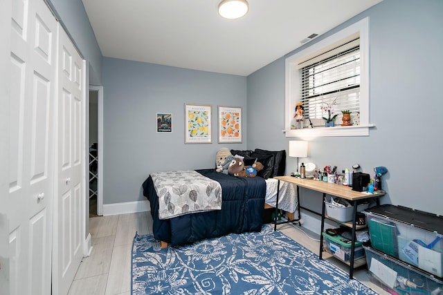 bedroom featuring baseboards, visible vents, and a closet