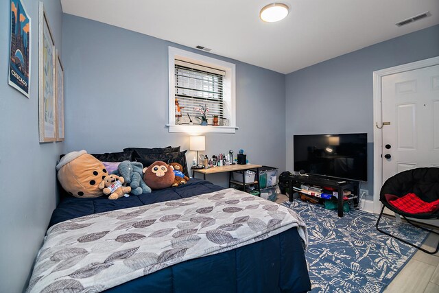 bedroom featuring wood finished floors, visible vents, and baseboards