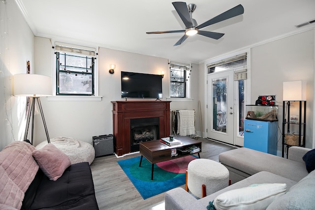 living area with ceiling fan, wood finished floors, visible vents, and plenty of natural light