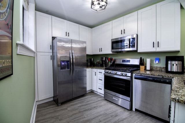 kitchen with white cabinets, light wood finished floors, and appliances with stainless steel finishes