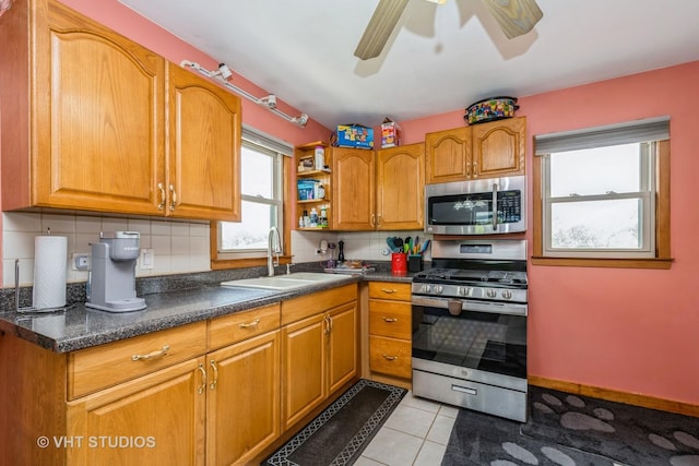 1216 Maple St, Lake In The Hills, IL 60156 - kitchen featuring appliances with stainless steel finishes, a sink, backsplash, a ceiling fan, and brown cabinetry