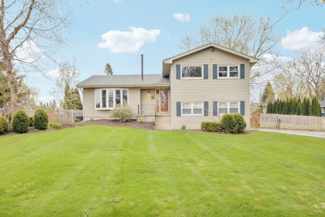 split level home with a front yard and fence