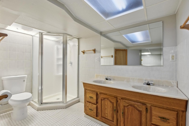 bathroom featuring tile walls, tile patterned floors, a shower stall, and toilet