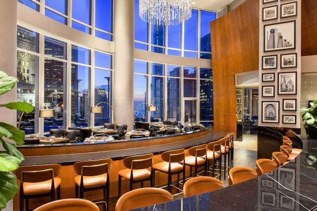 401 N Wabash Ave Unit 49G, Chicago, IL 60611 - bar with hardwood / wood-style flooring, a view of city, a towering ceiling, and an inviting chandelier