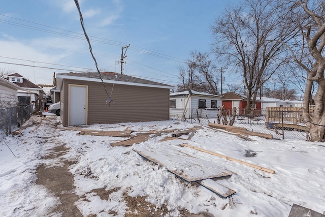 7740 S Vernon Ave, Chicago, IL 60619 - snow covered rear of property featuring an outdoor structure, fence, and a residential view