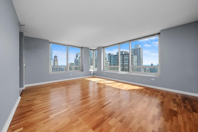 33 W Ontario St Unit 46A, Chicago, IL 60654 - empty room with light wood-style floors, baseboards, and a view of city