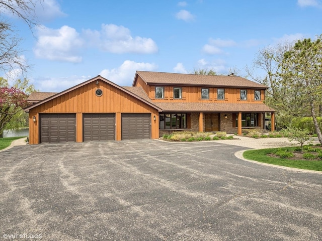 view of front of house featuring a porch, aphalt driveway, roof with shingles, and a garage