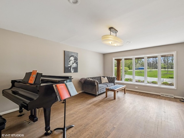 living room with visible vents, baseboards, and wood finished floors