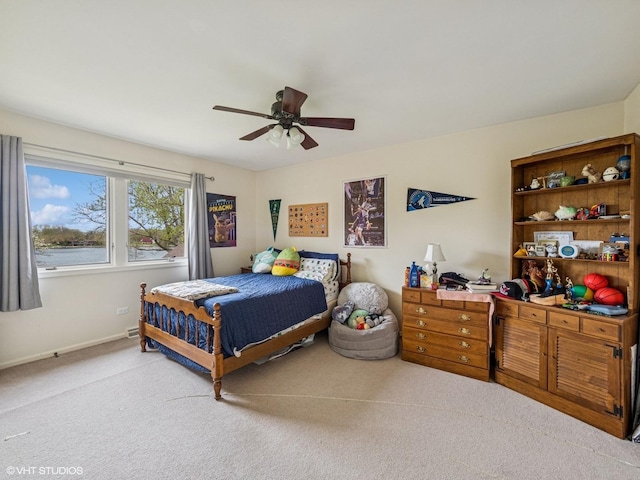 bedroom featuring light colored carpet, baseboards, and ceiling fan