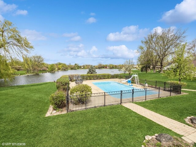 view of swimming pool featuring fence, a water slide, a fenced in pool, a water view, and a lawn