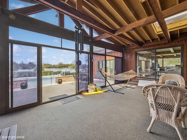 sunroom with a water view and beam ceiling