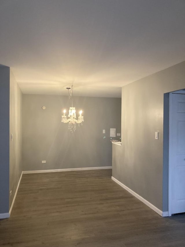 6300 N Sheridan Rd Unit 517, Chicago, IL 60660 - unfurnished room featuring an inviting chandelier, dark wood-style flooring, and baseboards