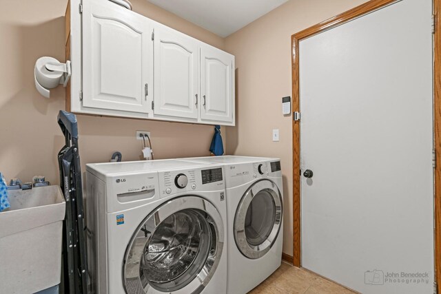 laundry room with cabinet space, independent washer and dryer, and light tile patterned flooring