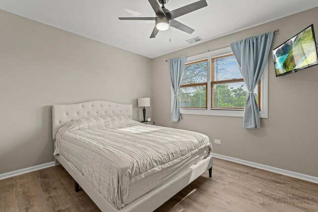 bedroom with wood finished floors, baseboards, and ceiling fan
