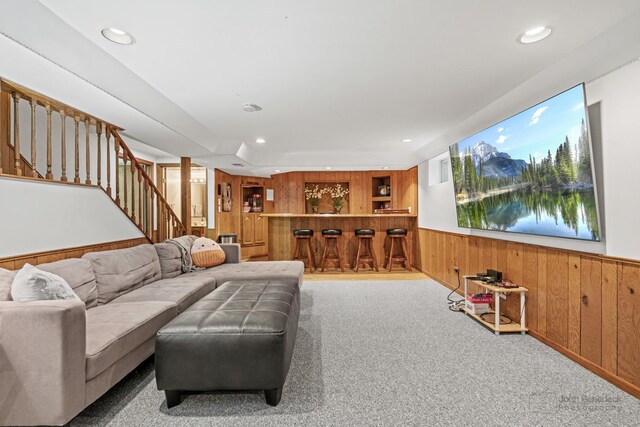 living room featuring wood walls, stairs, wainscoting, carpet, and recessed lighting