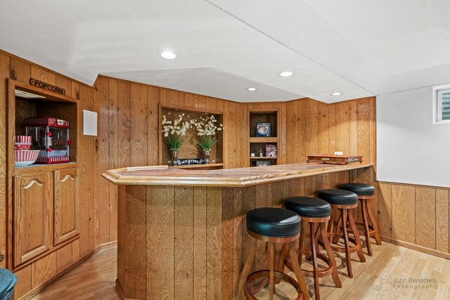 indoor wet bar featuring wood walls, light wood-type flooring, and recessed lighting