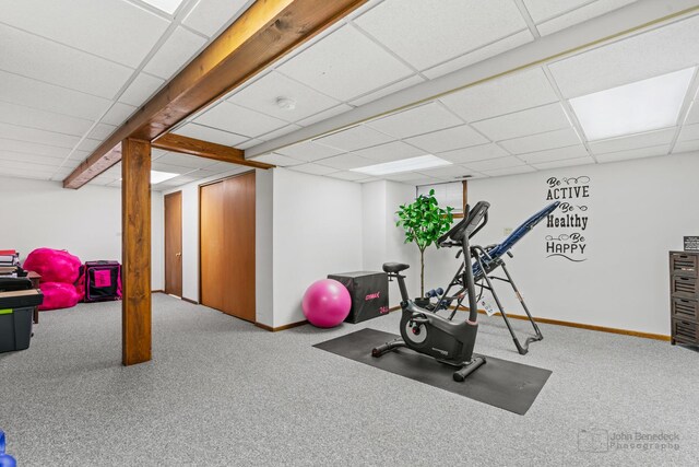 exercise room with a drop ceiling, carpet flooring, and baseboards