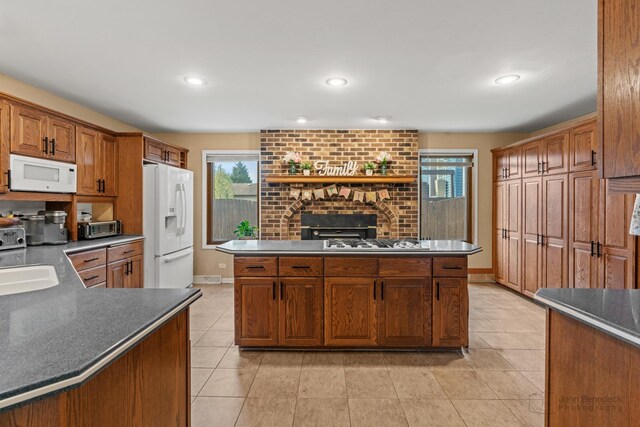 kitchen with white appliances, dark countertops, light tile patterned floors, plenty of natural light, and recessed lighting