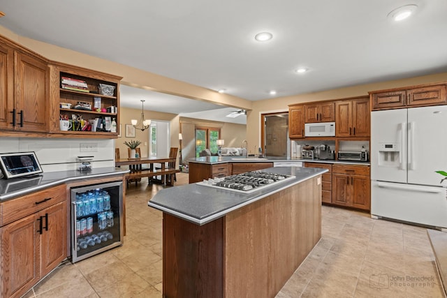 kitchen with white appliances, beverage cooler, a sink, brown cabinetry, and open shelves