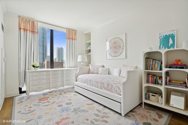 bedroom featuring crown molding and wood finished floors