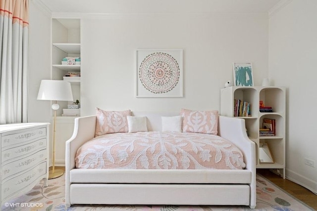 bedroom featuring crown molding, baseboards, and wood finished floors