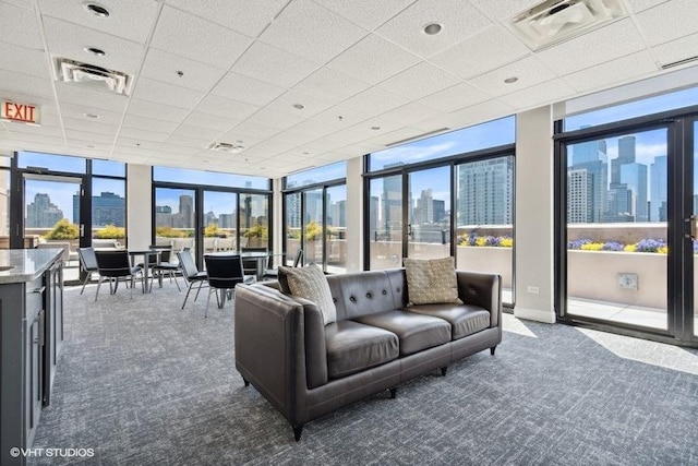 interior space featuring a view of city, a drop ceiling, dark carpet, and visible vents
