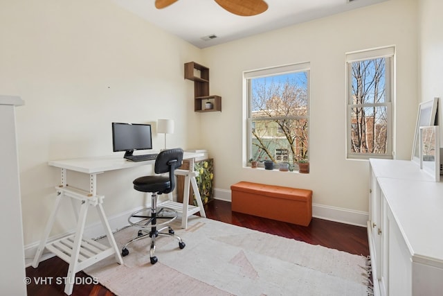 hall featuring baseboards, wood finished floors, and visible vents