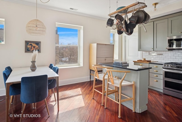 kitchen with stainless steel appliances, dark countertops, visible vents, crown molding, and baseboards
